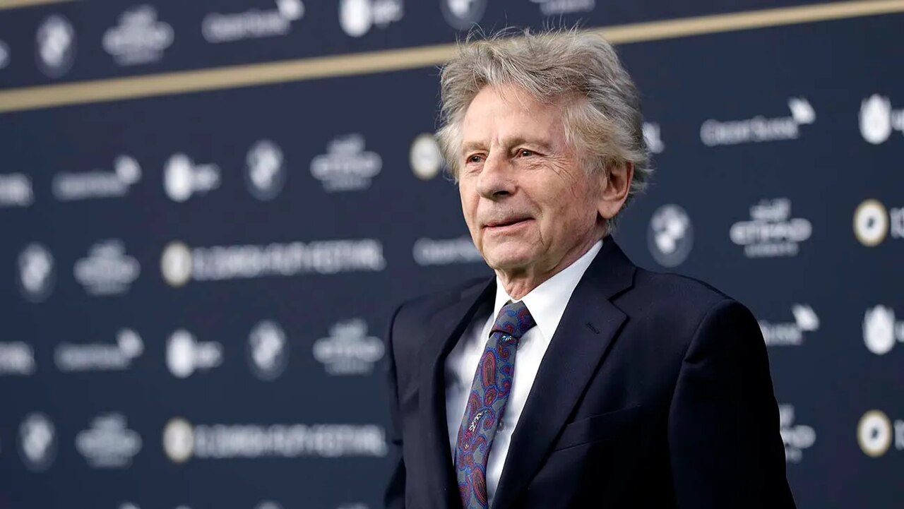 Roman Polanski de terno sorrindo